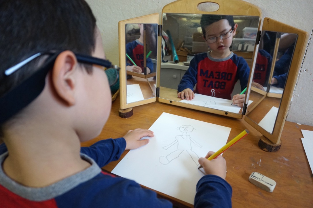 A child drawing a self-portrait