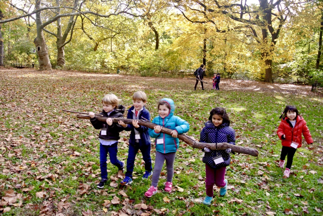 children carrying a log in Central Park